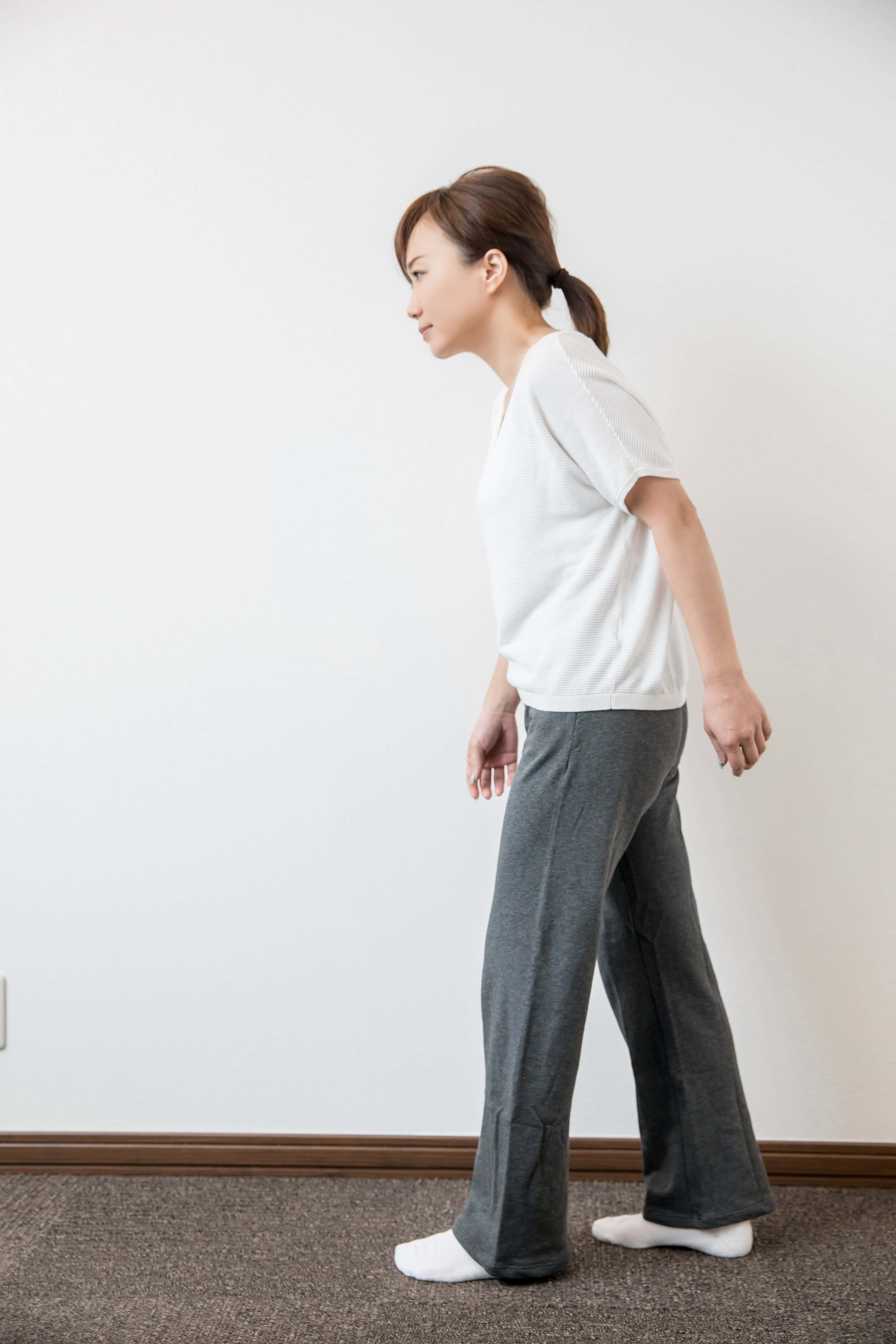 woman walking with a bent over posture, a sign of spinal stenosis