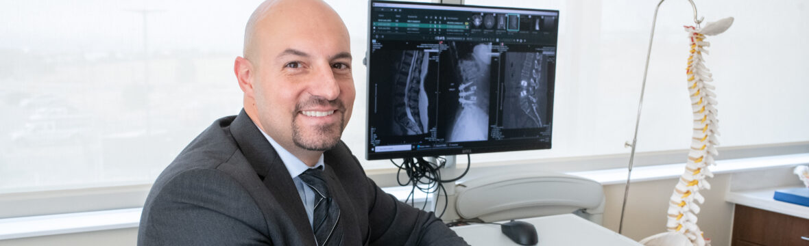 Dr. Asfahani with a patient's spine imaging for plif surgery.