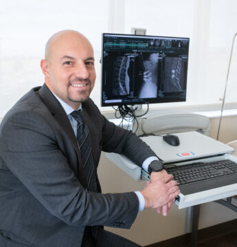 Dr. Asfahani with a patient's spine imaging for plif surgery.