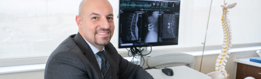 Dr. Asfahani with a patient's spine imaging for plif surgery.